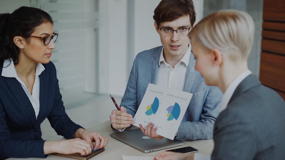 Angry businessman disappointed with company financial reports and scolding employees sitting at the table in meeting room indoors